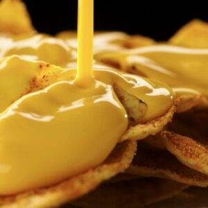 Cheese sauce poured over tortilla chips