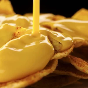 Cheese sauce poured over tortilla chips
