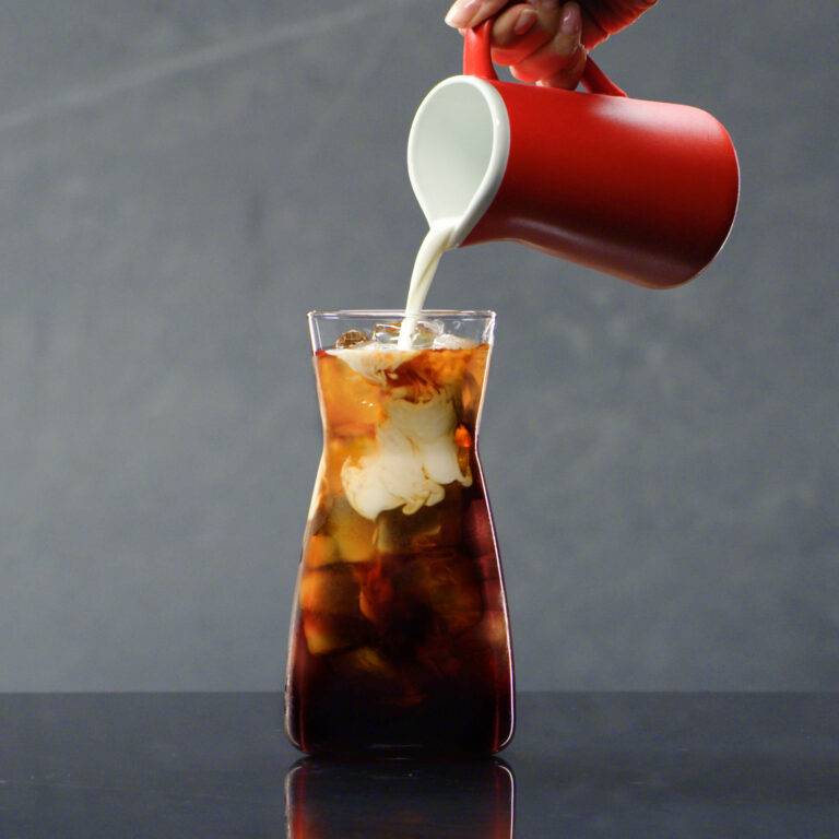creamer poured into ice coffee
