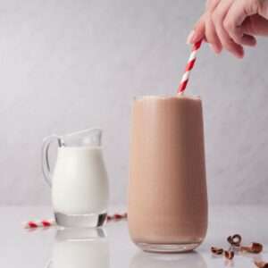 chocolate milk in a glass with paper straw