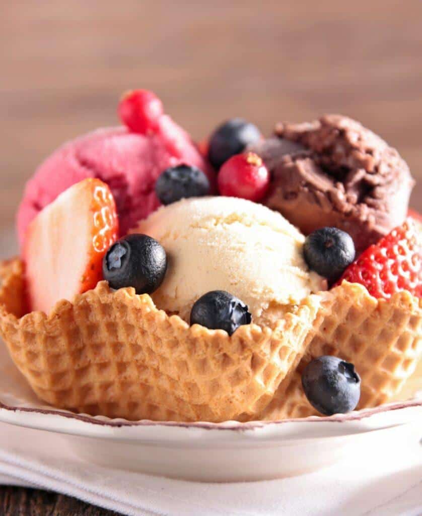vanilla ice cream with berries in a waffle cone bowl