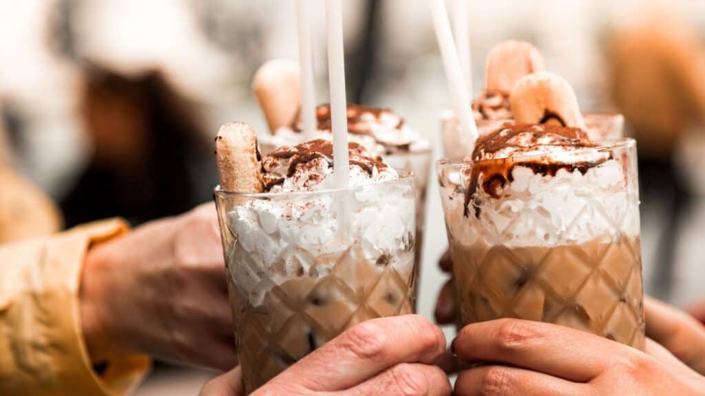 Delicious caramel and condensed milk drinks topped with whipped cream and cookies, showcasing functional sweet browns.