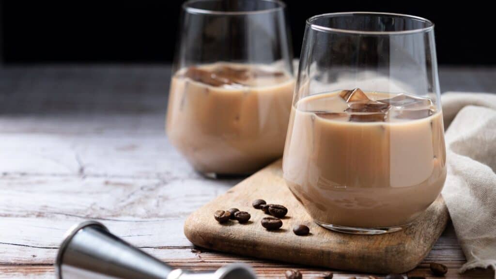 Two glasses of Irish cream with ice on a wooden surface.irish-cream-beverage