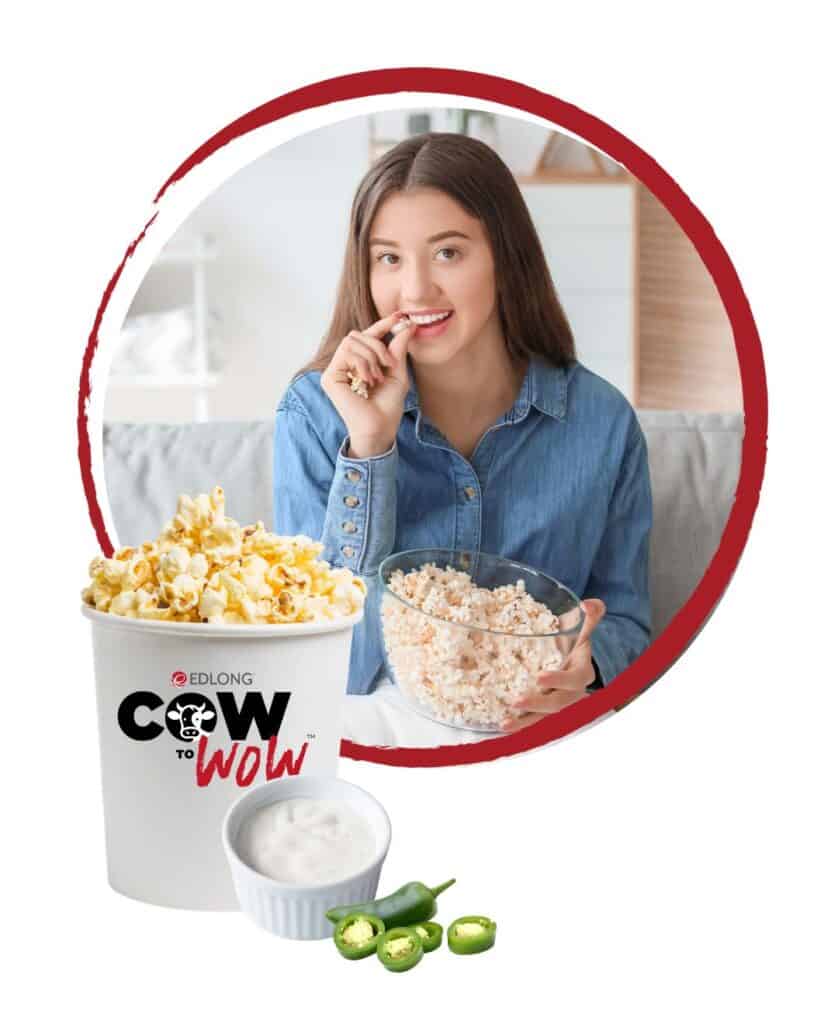Young woman enjoying popcorn and snacks while watching a movie at home.